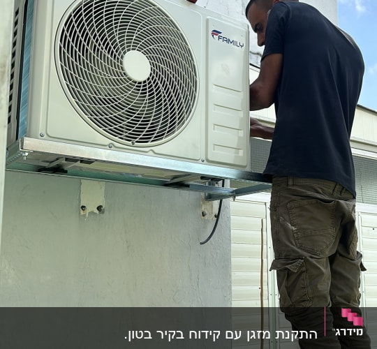 טכנאי מתקין מזגן על קיר חיצוני